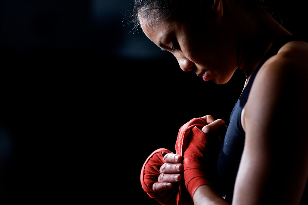 Girl straightens boxing red bandages on her hands