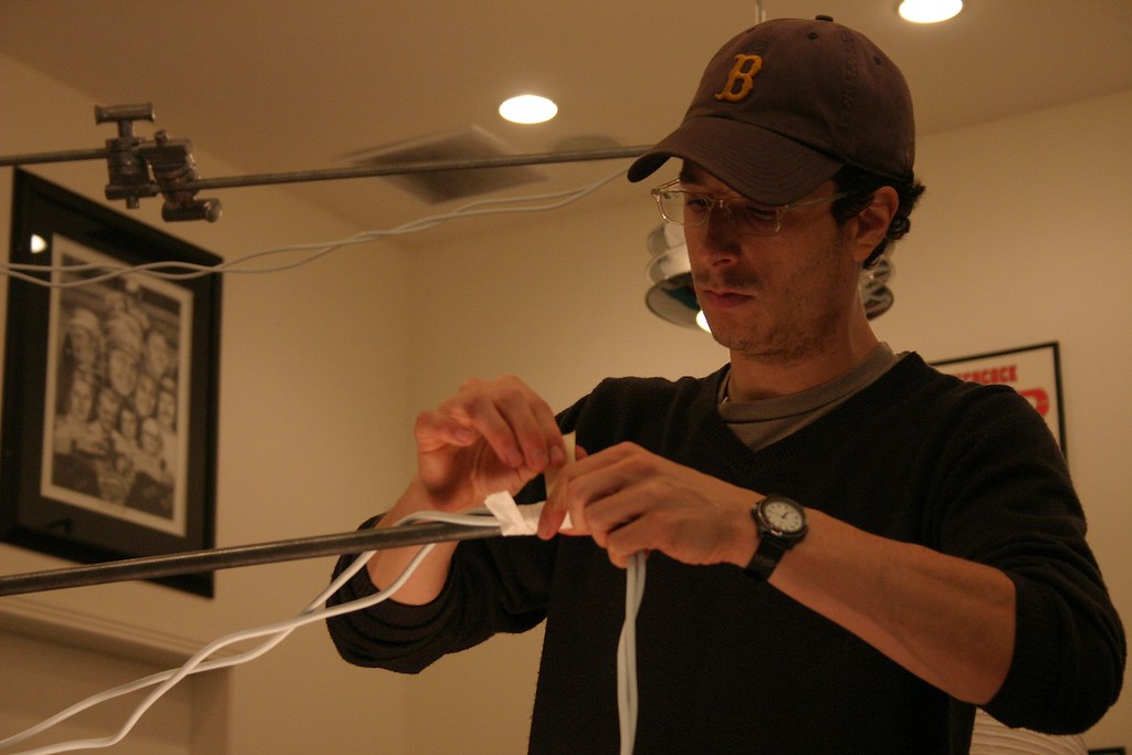 A man seals an object like a table lamp with duct tape